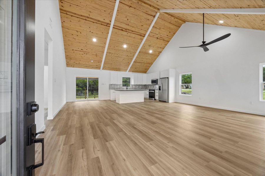Natural wood ceilings crown an open-concept living space with a stylish kitchen. Natural wood ceilings crown an open-concept living space with a stylish kitchen.