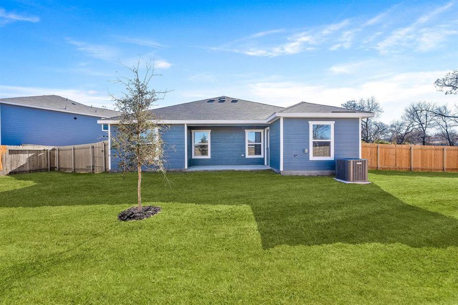 Rear view of house featuring a lawn and cooling unit