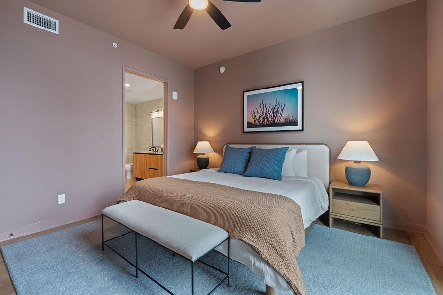Representative Photo. Primary Bedroom with wood flooring, large window, ceiling fan, and window treatments included