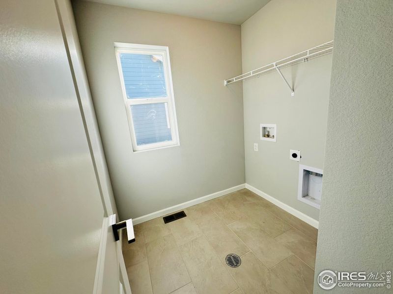 2nd floor laundry room with tiled flooring