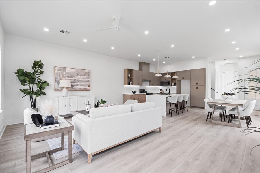 The living room feels grand and expansive, with soaring ceilings and an open layout that invite gathering and connection. Floor-to-ceiling windows bathe the space in natural light, highlighting every detail and creating a warm, welcoming atmosphere.