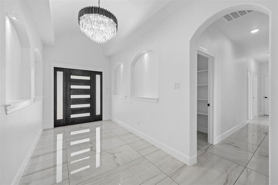 Tiled entrance foyer with a notable chandelier