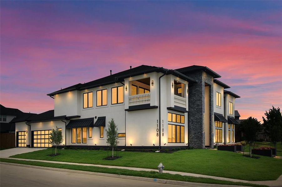 View of front of home featuring a lawn and a balcony