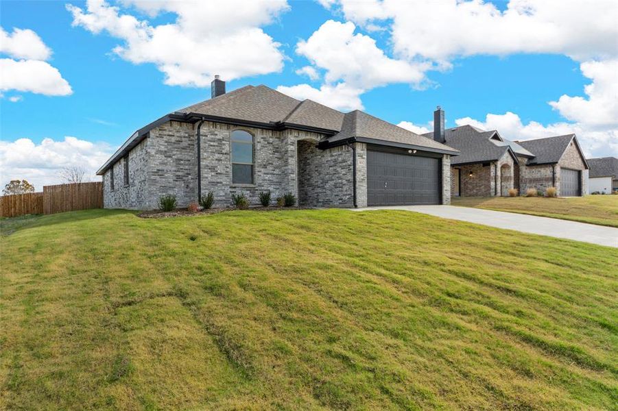 View of front of home with a front yard and a garage