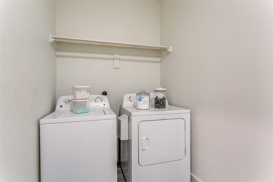 Washroom featuring a textured wall and washer and clothes dryer Washroom featuring a textured wall and washer and clothes dryer