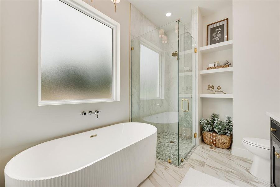 Full bath with a soaking tub, a marble finish shower, vanity, built in features, and light marble finish floors