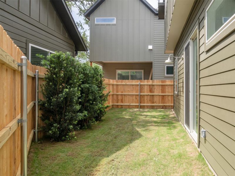Private backyard featuring a manicured lawn, full privacy fencing, and established shrubbery