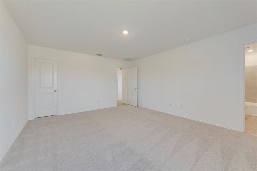 Empty room featuring light colored carpet