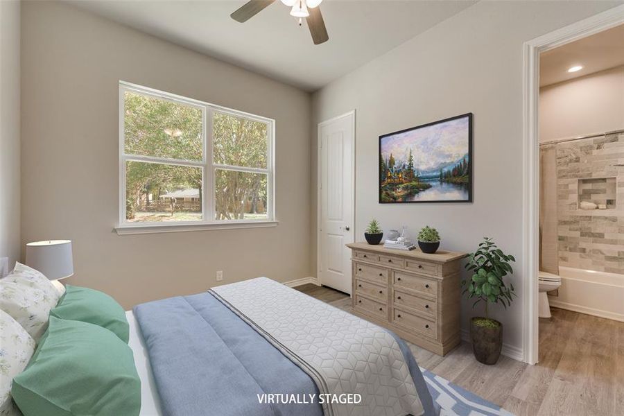 Bedroom with connected bathroom, light hardwood / wood-style flooring, and ceiling fan