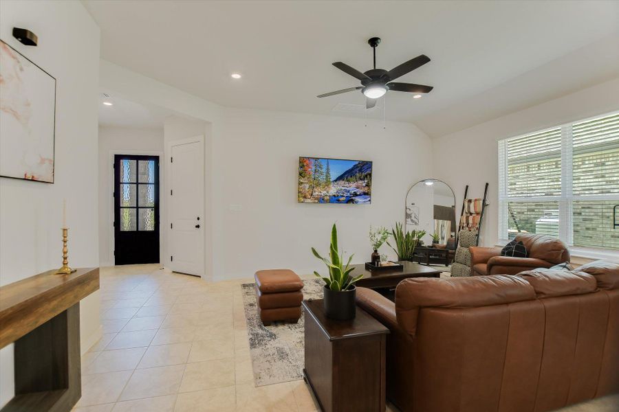 A welcoming living area boasts neutral tile flooring and recessed lighting, leading to a charming entryway. A welcoming living area boasts neutral tile flooring and recessed lighting, leading to a charming entryway.