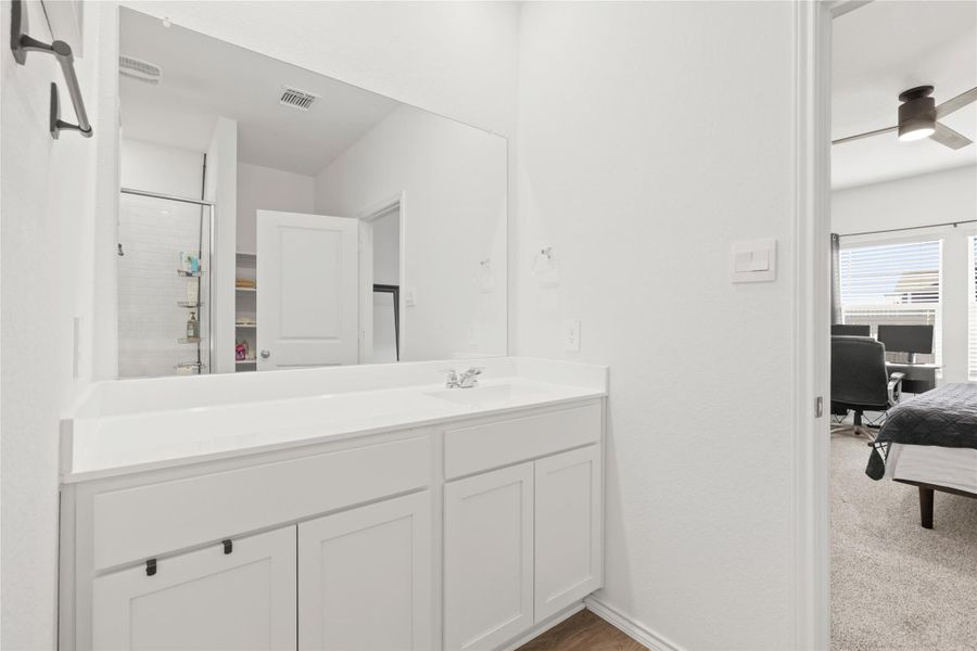 Spa-like serenity! This primary ensuite features a crisp, all-white double vanity with a mirror and a sleek glass-enclosed walk-in shower, creating the perfect atmosphere for your morning routine.