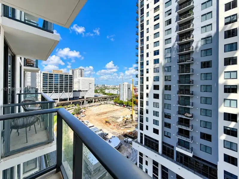 Private balcony featuring a glass-panel railing and concrete flooring Private balcony featuring a glass-panel railing and concrete flooring
