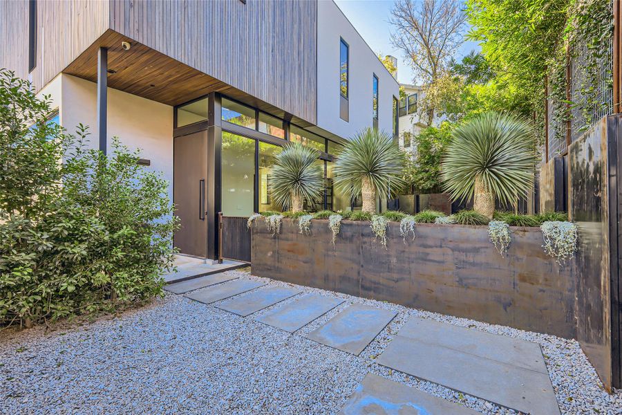 A modern architectural marvel showcasing a sleek facade with rich wood accents and striking desert landscaping. A modern architectural marvel showcasing a sleek facade with rich wood accents and striking desert landscaping.