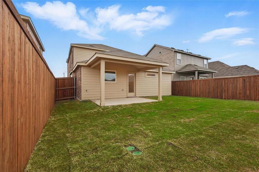 Rear view of property with a fenced backyard, a patio, and a yard Rear view of property with a fenced backyard, a patio, and a yard