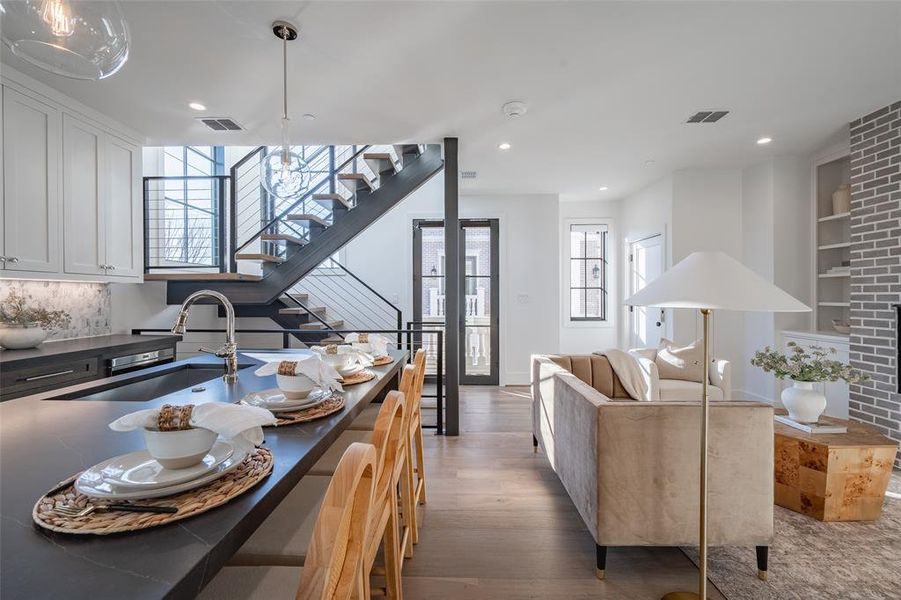 Kitchen with white cabinetry, sink, built in features, plenty of natural light, and decorative light fixtures