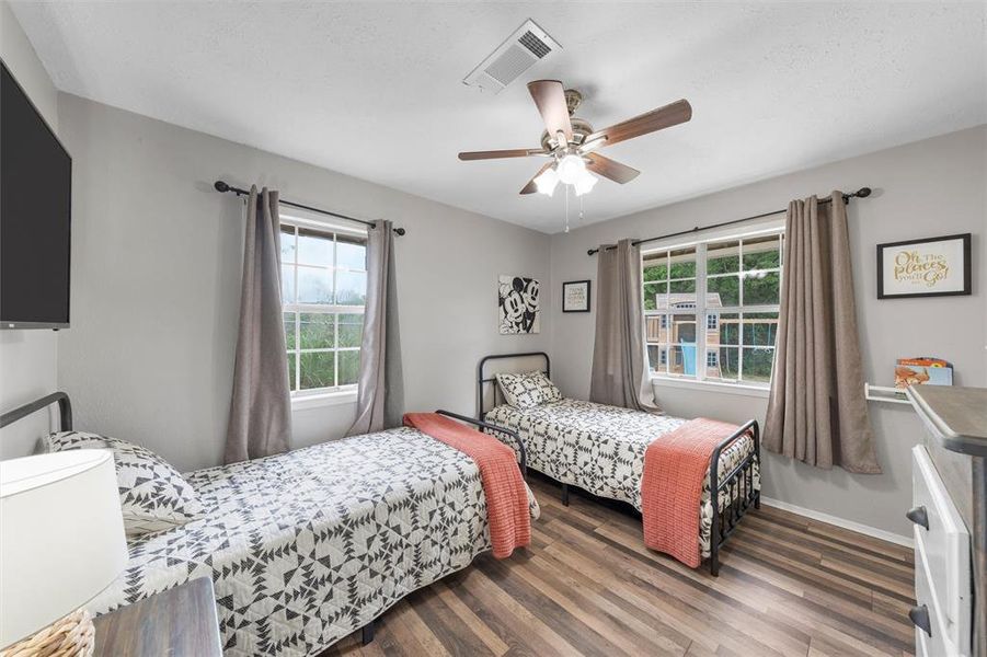 Bedroom featuring wood finished floors, ceiling fan, and baseboards Bedroom featuring wood finished floors, ceiling fan, and baseboards