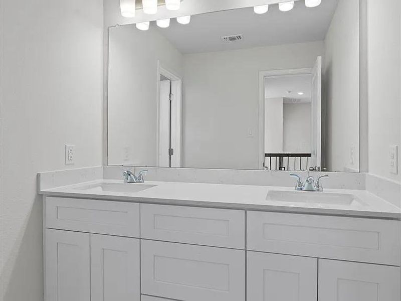 Double vanity with pristine counters and contemporary fixtures.