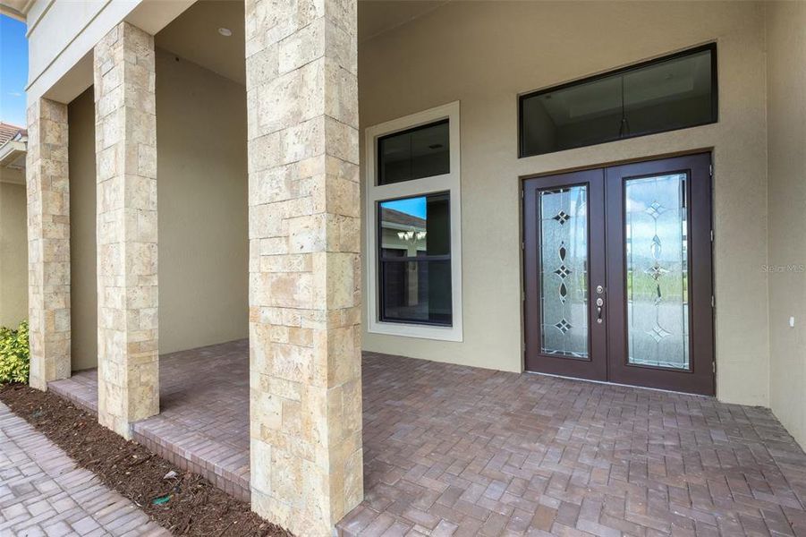 Double door entry with covered front paver porch.