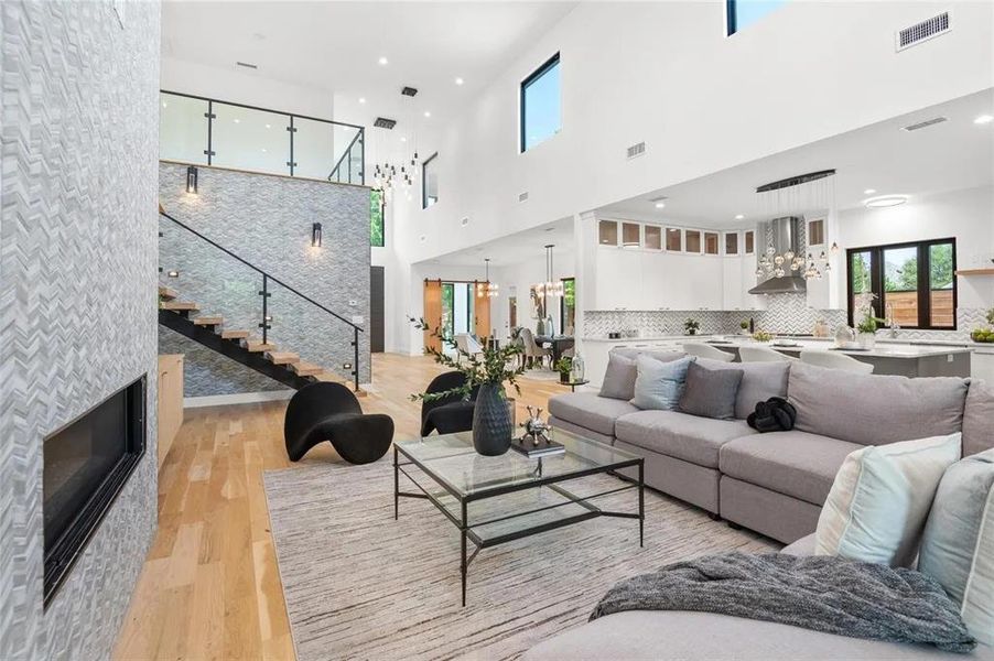 Open-concept living area with soaring ceilings and light wood-finish flooring Open-concept living area with soaring ceilings and light wood-finish flooring