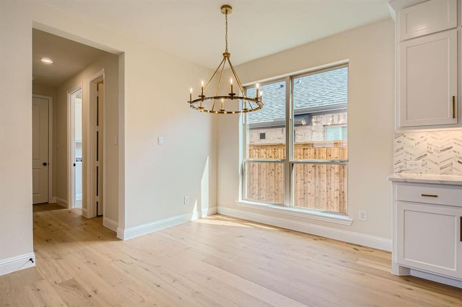 Unfurnished dining area with a notable chandelier and light wood-type flooring