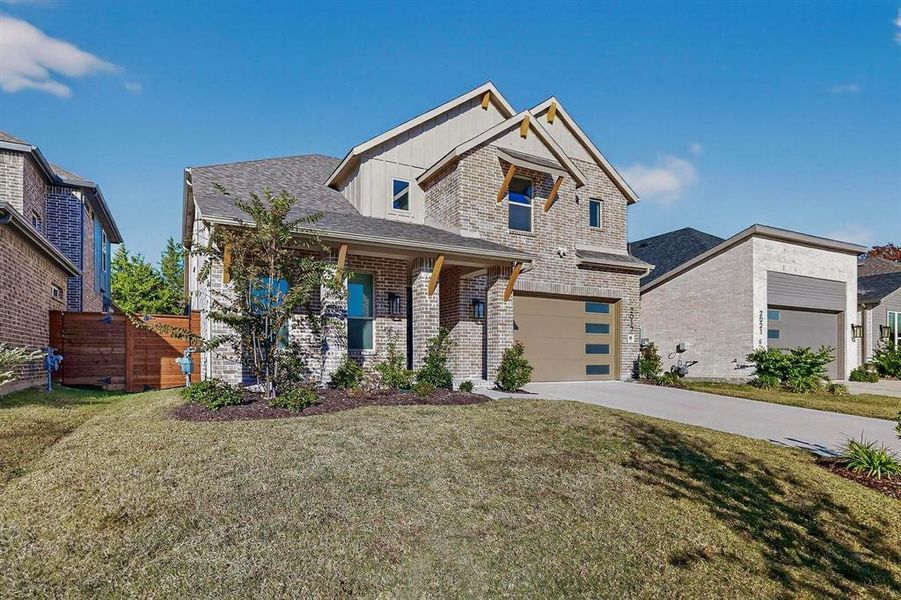 View of front of property featuring driveway, brick siding, a porch, roof with shingles, and a garage View of front of property featuring driveway, brick siding, a porch, roof with shingles, and a garage