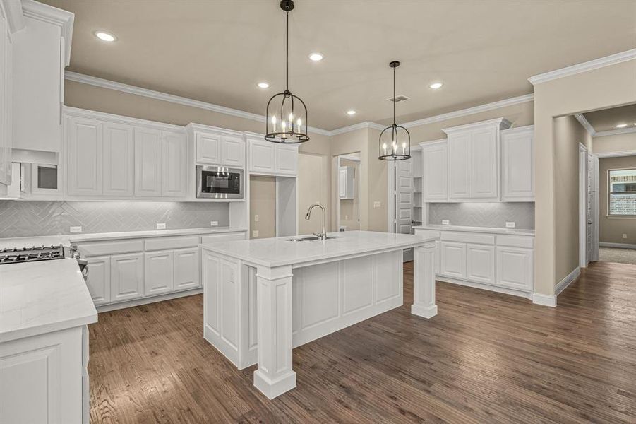 Kitchen with decorative backsplash, black microwave, dark hardwood / wood-style floors, and white cabinets