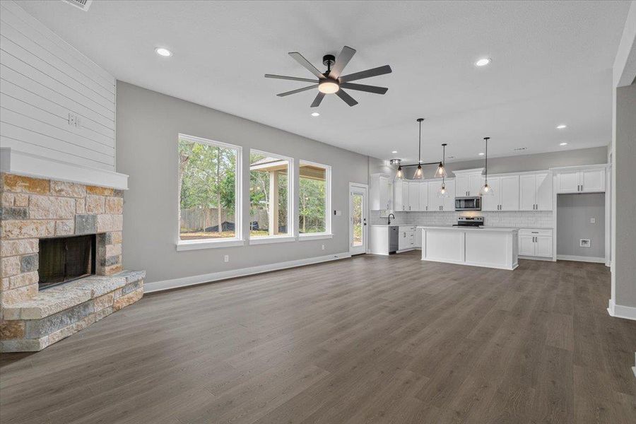 An open-concept living space integrates a modern kitchen and a cozy fireplace, framed by large windows. An open-concept living space integrates a modern kitchen and a cozy fireplace, framed by large windows.