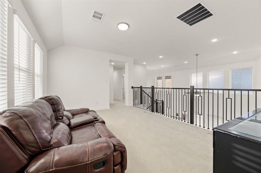 Living area with carpet floors and an upstairs landing