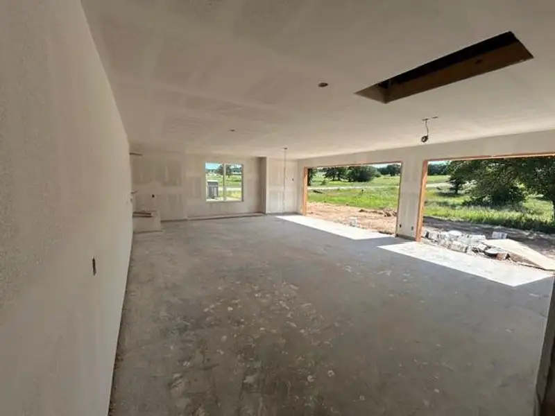 Unfinished interior space featuring a concrete slab floor and drywall-ready walls Unfinished interior space featuring a concrete slab floor and drywall-ready walls