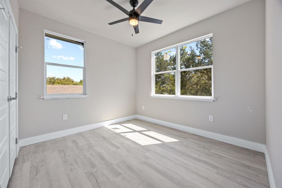 Unfurnished room featuring light wood-style floors, ceiling fan, and baseboards Unfurnished room featuring light wood-style floors, ceiling fan, and baseboards