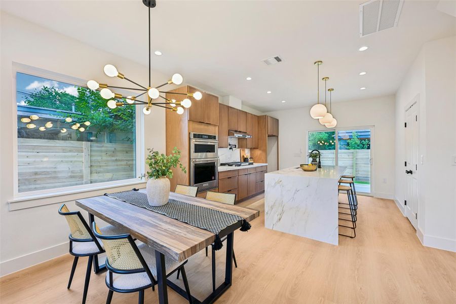 A contemporary kitchen with integrated appliances and a spacious quartz island, ideal for casual dining.