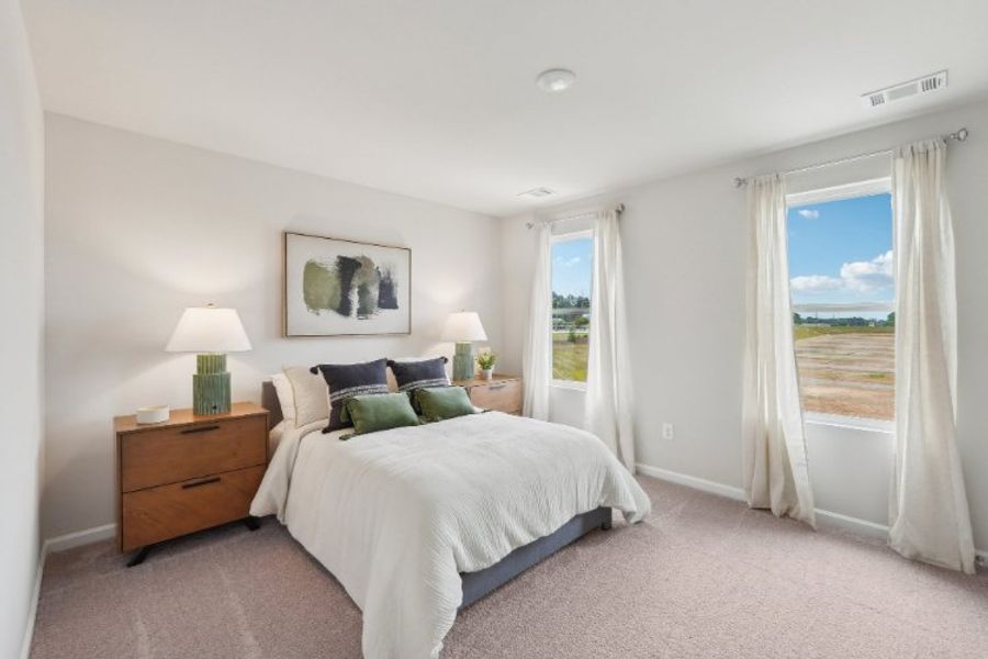 A bedroom with a large window. A bedroom with a large window.