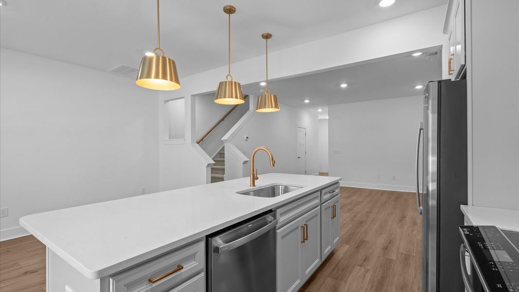 Memorable meals begin in this vibrant kitchen with pendant lighting and a thoughtfully designed island at Gresham Station