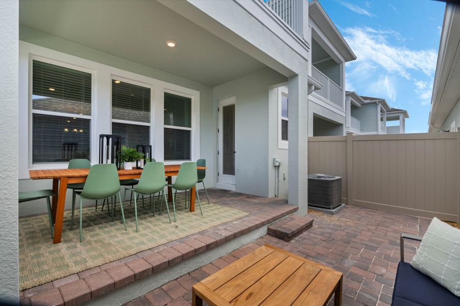Exterior details and patio area of a home in Harvest at Ovation - Townhomes, Winter Garden (Image 21).