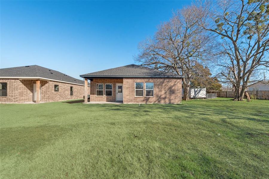 Rear view of property featuring a yard and a patio area