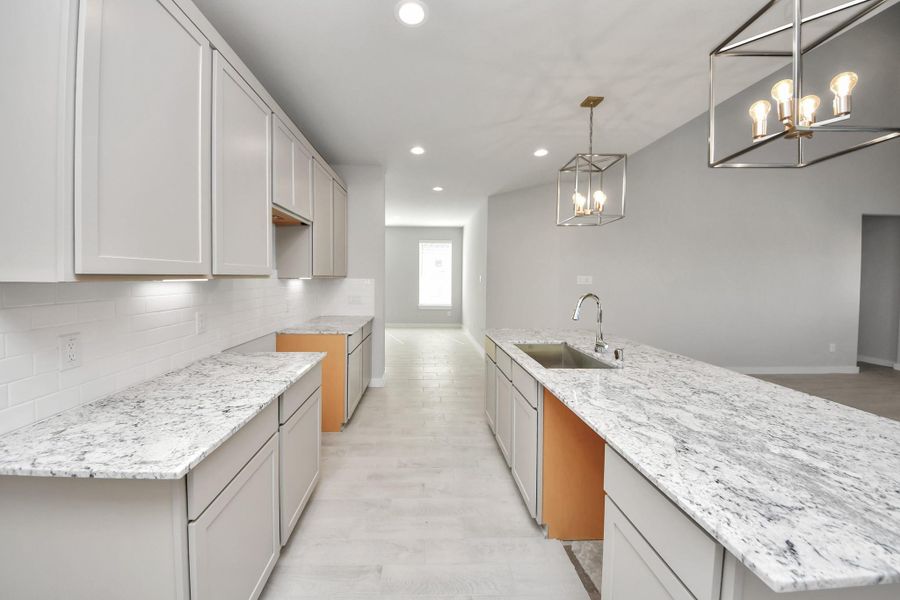 Discover another perspective of this stunning kitchen, generously appointed with an abundance of counter space. Sample photo of completed home with similar floor plan. Actual colors and selections may vary.
