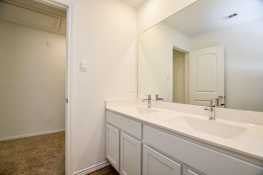 This photo shows a modern bathroom with a double sink vanity and a large mirror. The space features clean, white cabinetry and fixtures, creating a bright and inviting atmosphere. This photo shows a modern bathroom with a double sink vanity and a large mirror. The space features clean, white cabinetry and fixtures, creating a bright and inviting atmosphere.
