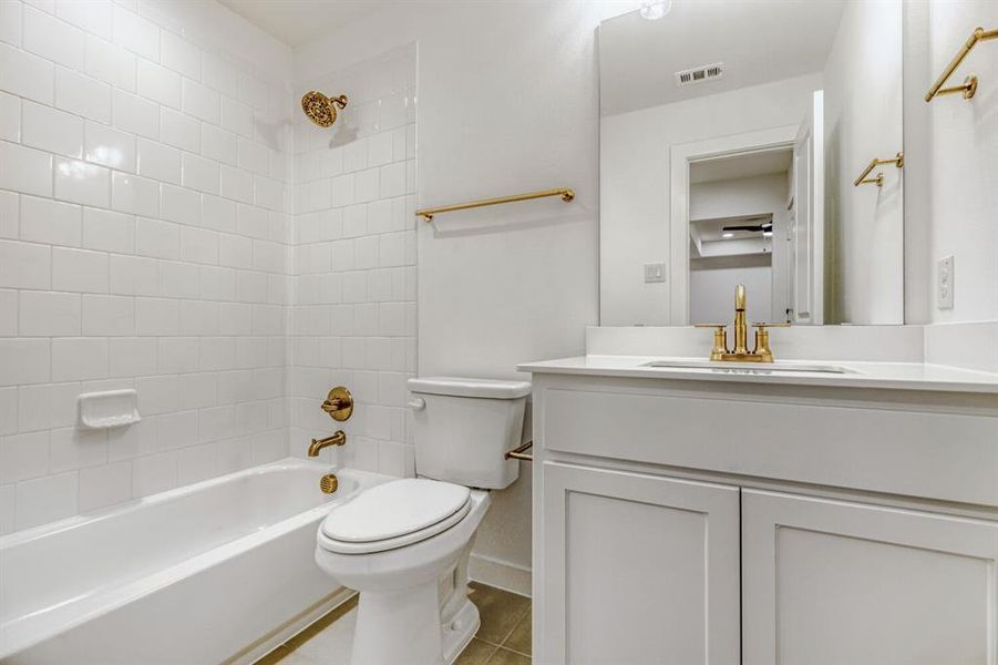 Bathroom with vanity, shower / bath combination, and light tile patterned flooring