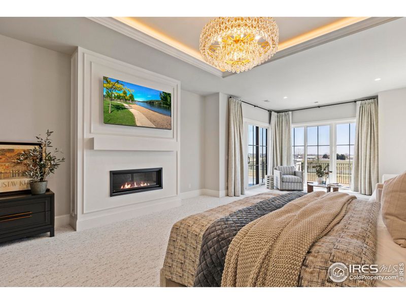 Spacious Primary Suite with gas fireplace, balcony access, built in cabinetry, and secure drawers