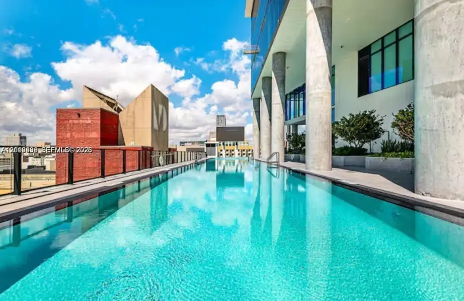 Infinity-edge lap pool featuring integrated structural columns, metal perimeter railing, and built-in landscape planters Infinity-edge lap pool featuring integrated structural columns, metal perimeter railing, and built-in landscape planters