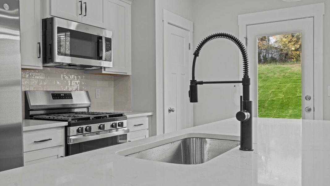 Accomplished kitchen design featuring pendant lighting above a statement island for both prep and gathering Accomplished kitchen design featuring pendant lighting above a statement island for both prep and gathering