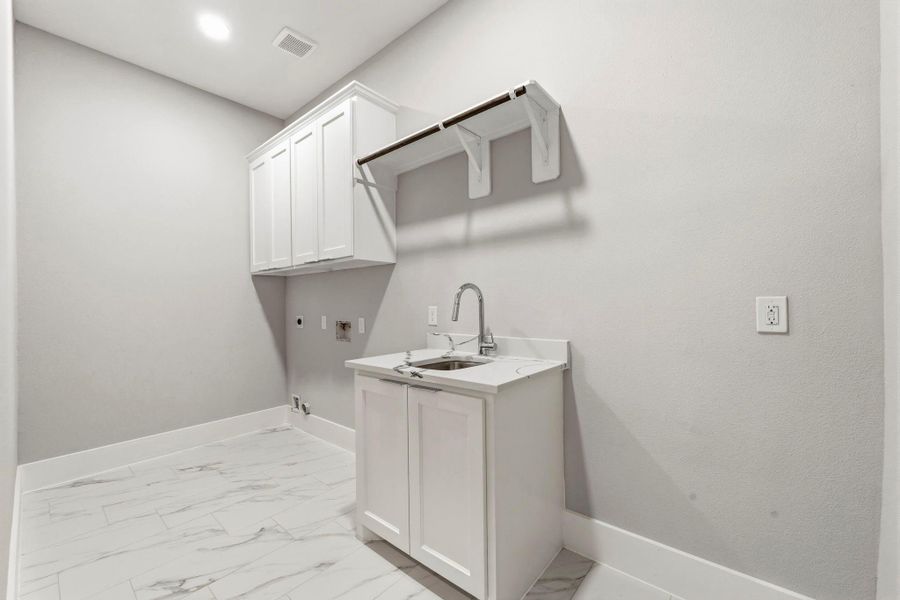 Large utility room includes sink and custom cabinetry.