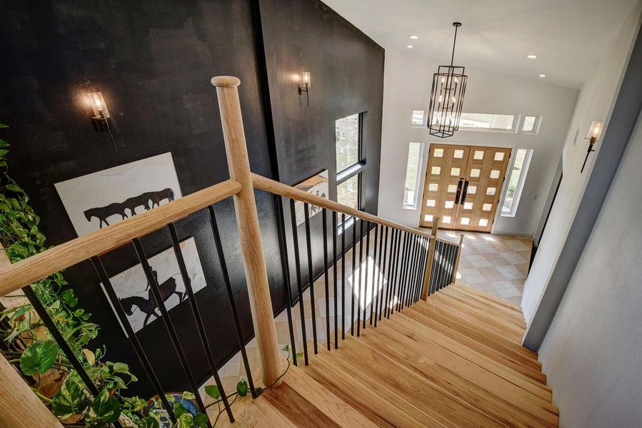 Foyer with light wood finished floors, a high ceiling, a chandelier, and recessed lighting Foyer with light wood finished floors, a high ceiling, a chandelier, and recessed lighting