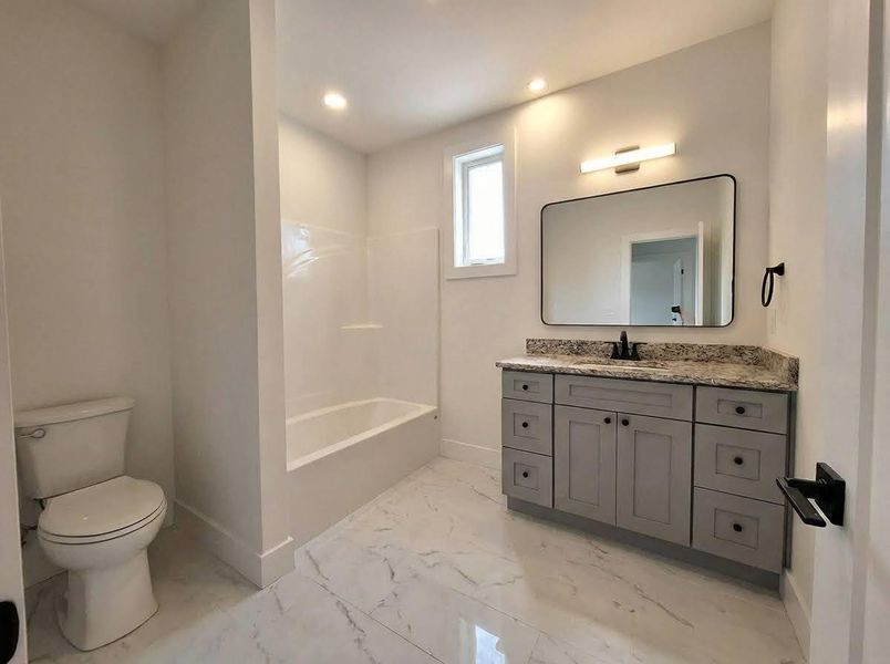Full bathroom featuring vanity, light marble finish floors, shower / washtub combination, and recessed lighting