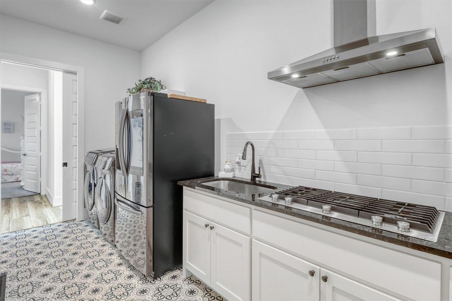 Yes! Want to cook without making a mess in the kitchen? Behind the kitchen is a second kitchen, featuring a gas stovetop, stainless steel vent hood, sink, and space for a refrigerator. Hide the prep and keep the main space clean for entertaining!