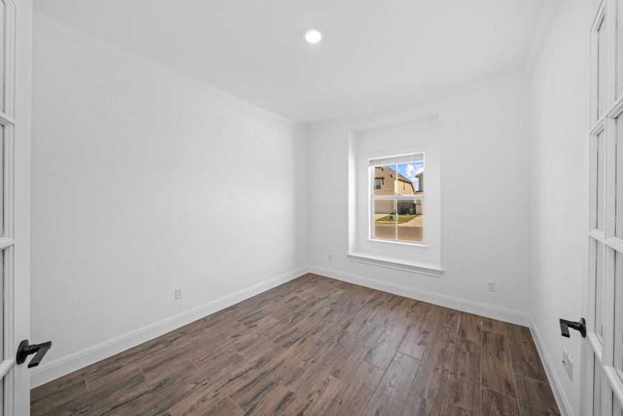 Unfurnished room featuring crown molding and dark wood finished floors Unfurnished room featuring crown molding and dark wood finished floors