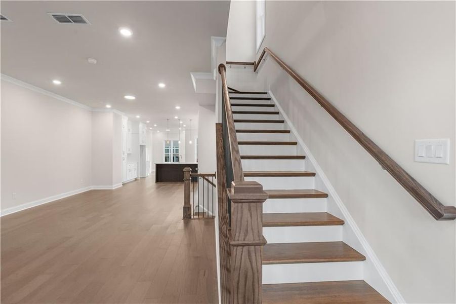 Stairway with recessed lighting, hardwood / wood-style flooring, and crown molding Stairway with recessed lighting, hardwood / wood-style flooring, and crown molding