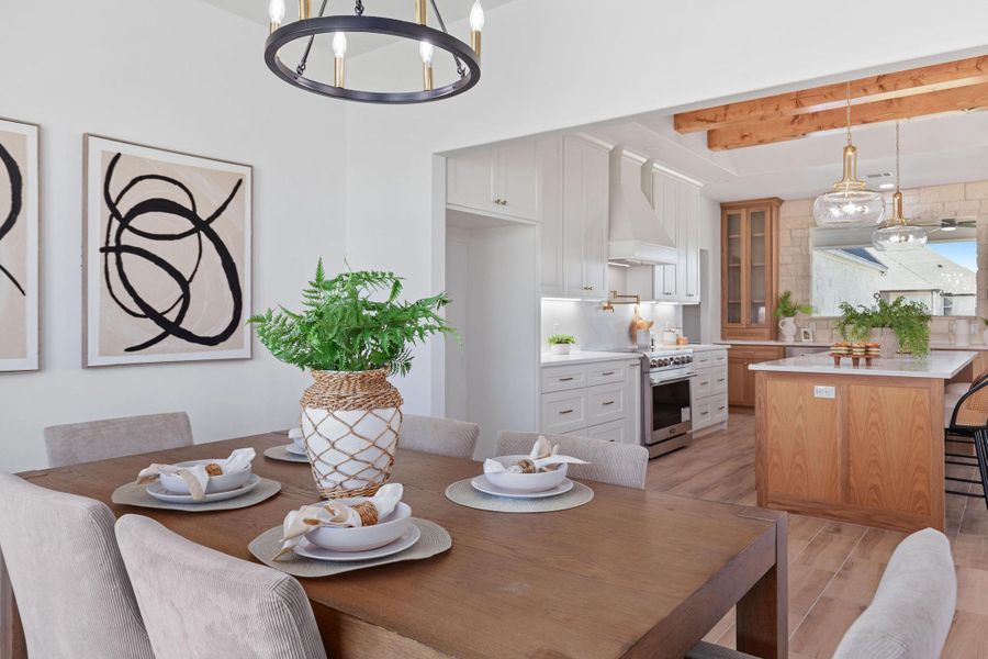 Dining room featuring suspended lighting, light wood finished floors, and beamed ceiling Dining room featuring suspended lighting, light wood finished floors, and beamed ceiling