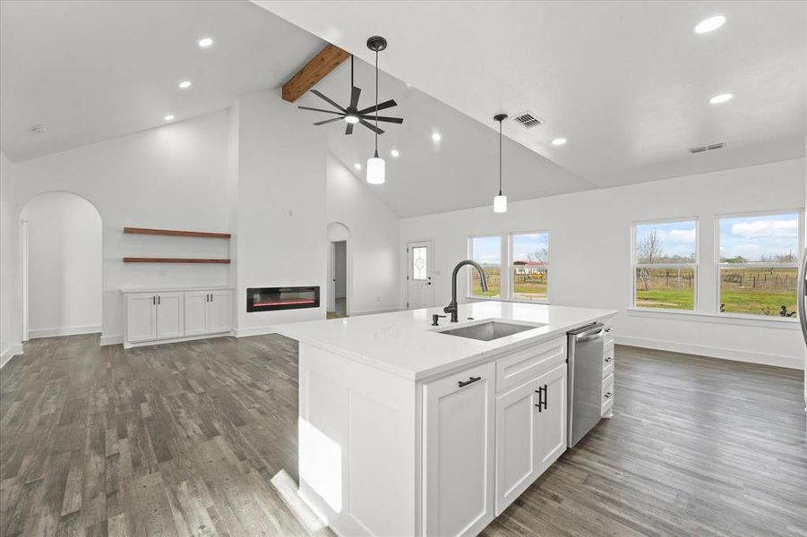 Kitchen with sink, dark wood-type flooring, dishwasher, an island with sink, and white cabinets