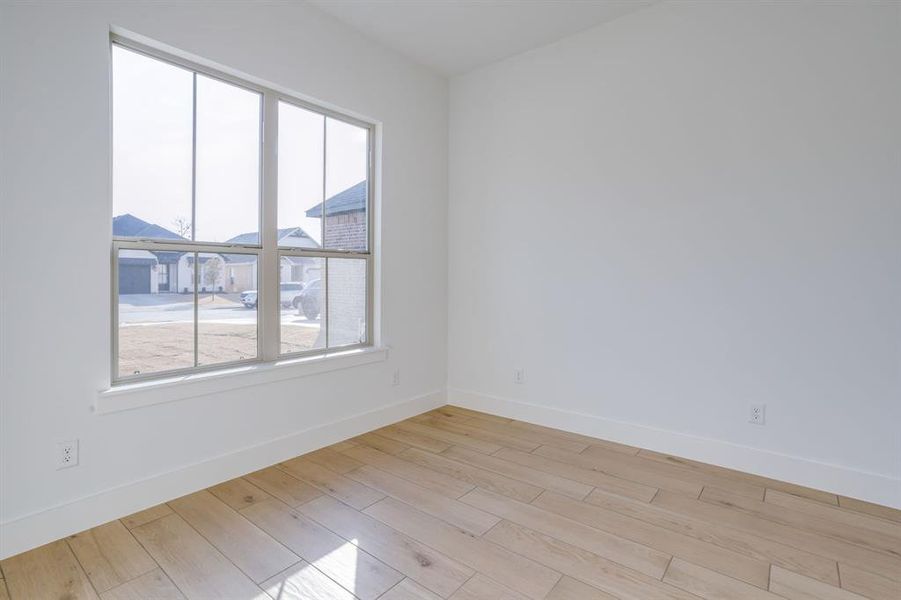 Spare room with baseboards and light wood-type flooring